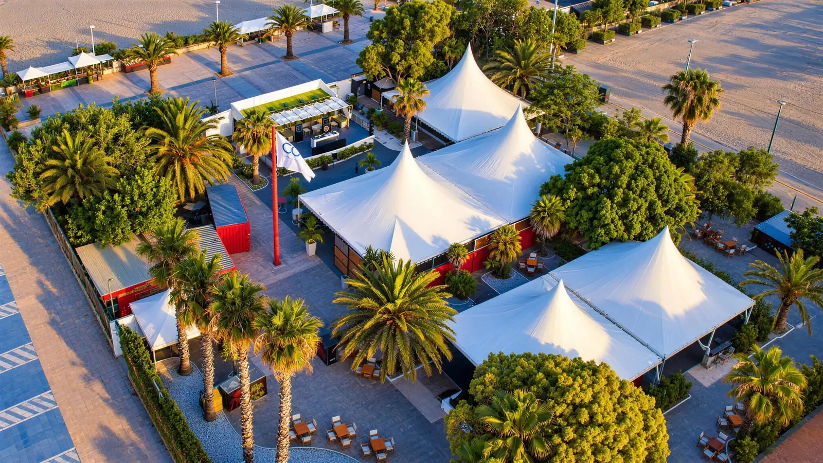 Cocoa Beach Club from the air: white marquees among the palm trees, right by the beach